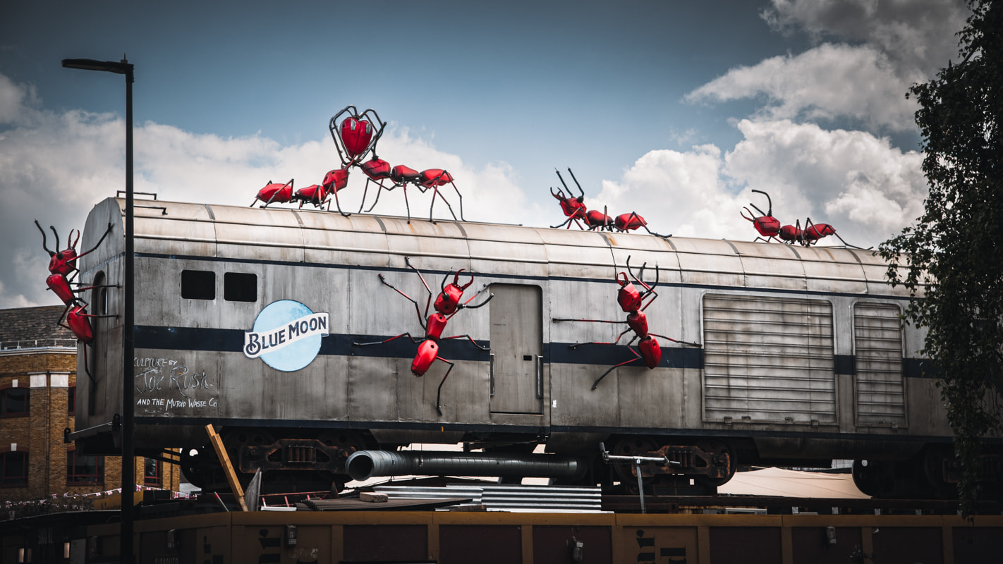 An art sculpture of giant ants crawling over a subway carriage